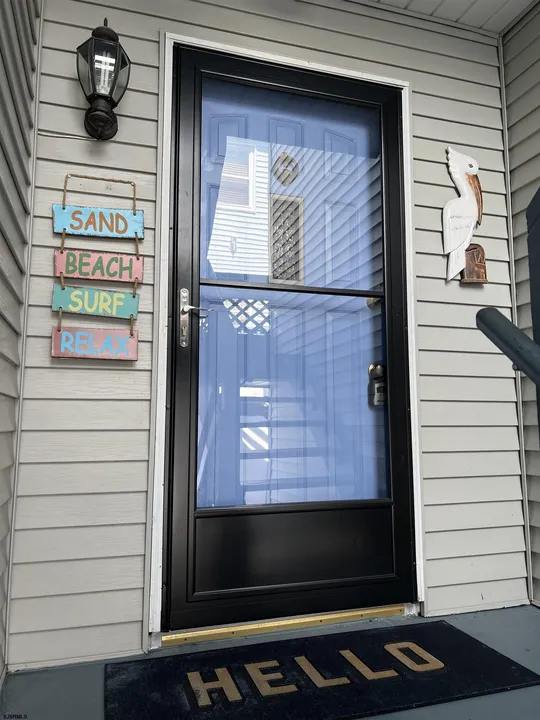We see a close up of the front door of a house adorned with greetings and welcome signs.