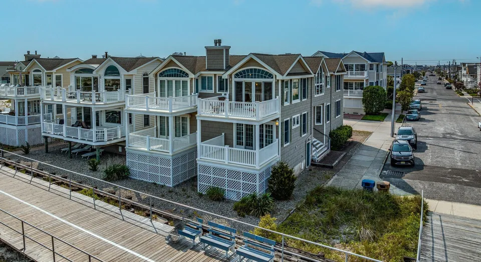 We see a grey and beige condominium in Ocean City, NJ against a clear blue sky.