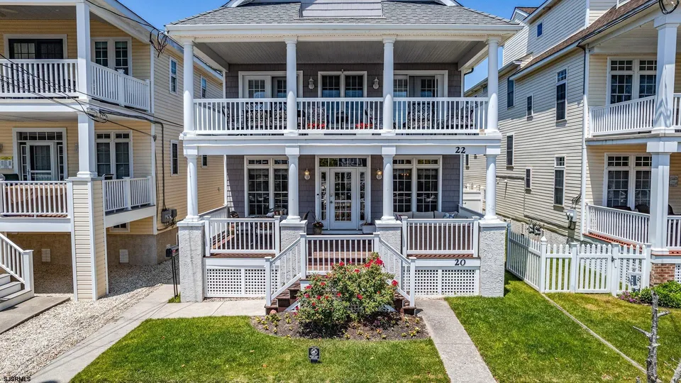 We see the front of a white and grey house in Ocean City, NJ against a clear and sunny day.