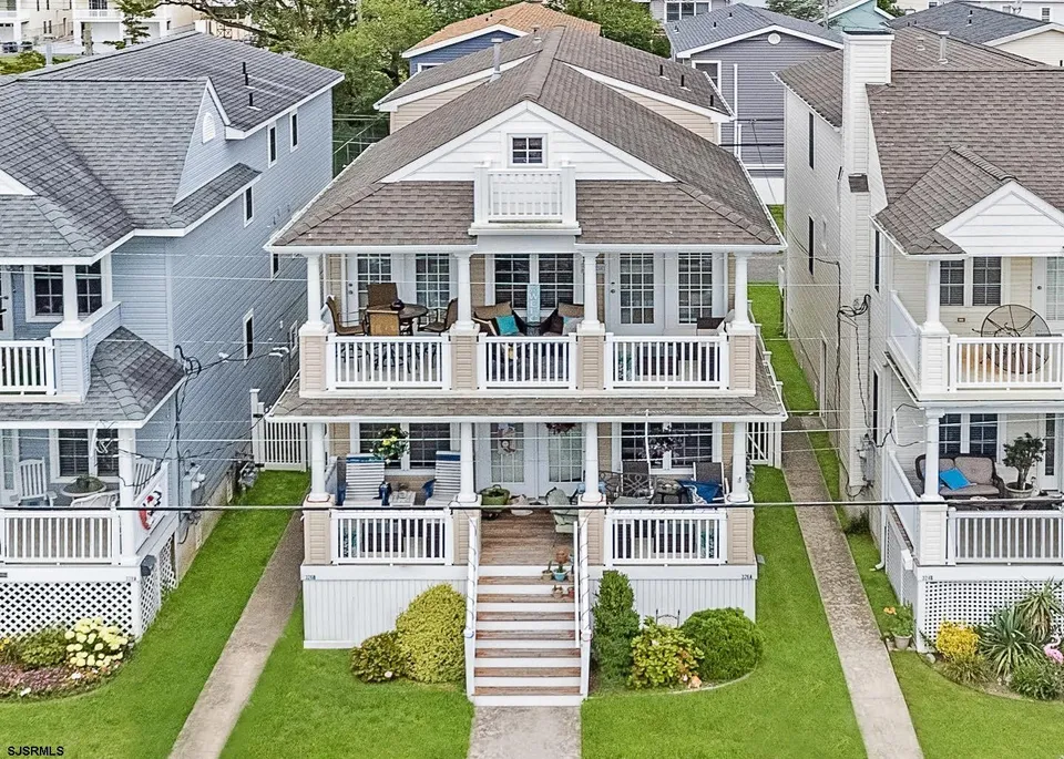 We see an aerial view of a beige and white, two-story home in Ocean City, NJ.